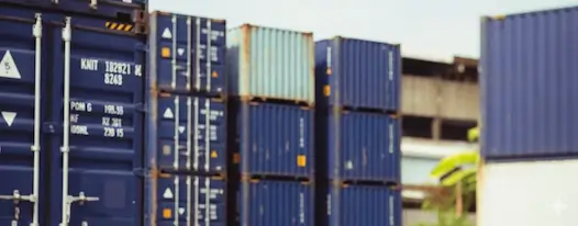 Close-up view of tall stacks of blue shipping containers in a storage yard, showing visible ID numbers, lock rods, and corner castings.