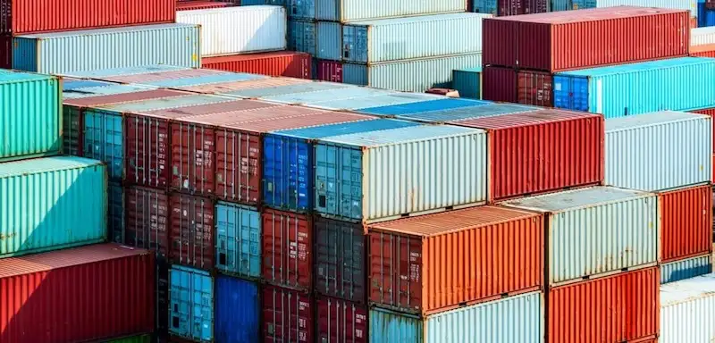 Densely stacked, multi-colored shipping containers (red, blue, white, orange) showing the huge inventory volume available.