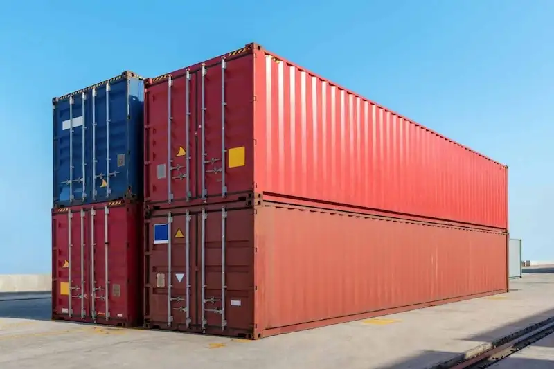 Two large 40ft red shipping containers stacked with a blue unit, emphasizing the popular size for storage and transport.