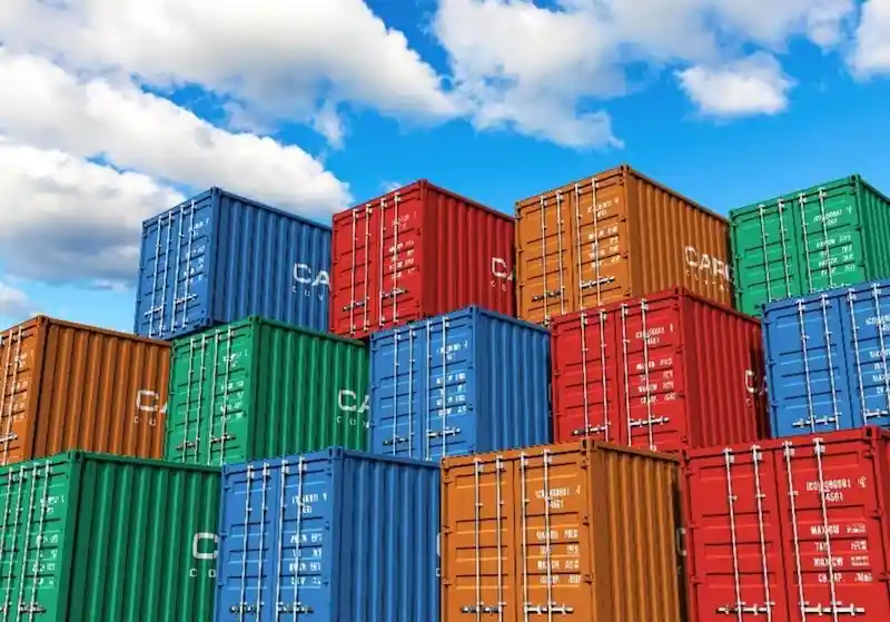 Colorful 3D render of shipping containers (red, blue, orange, green) stacked high against a bright blue sky.
