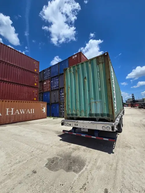 A 40ft high cube container secured on a tilt-bed truck 